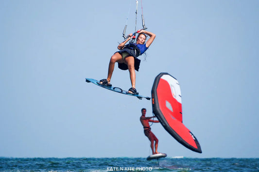 Kitesurfer jumping in the air above a wingfoiler on flat water in Hungary lake Velence